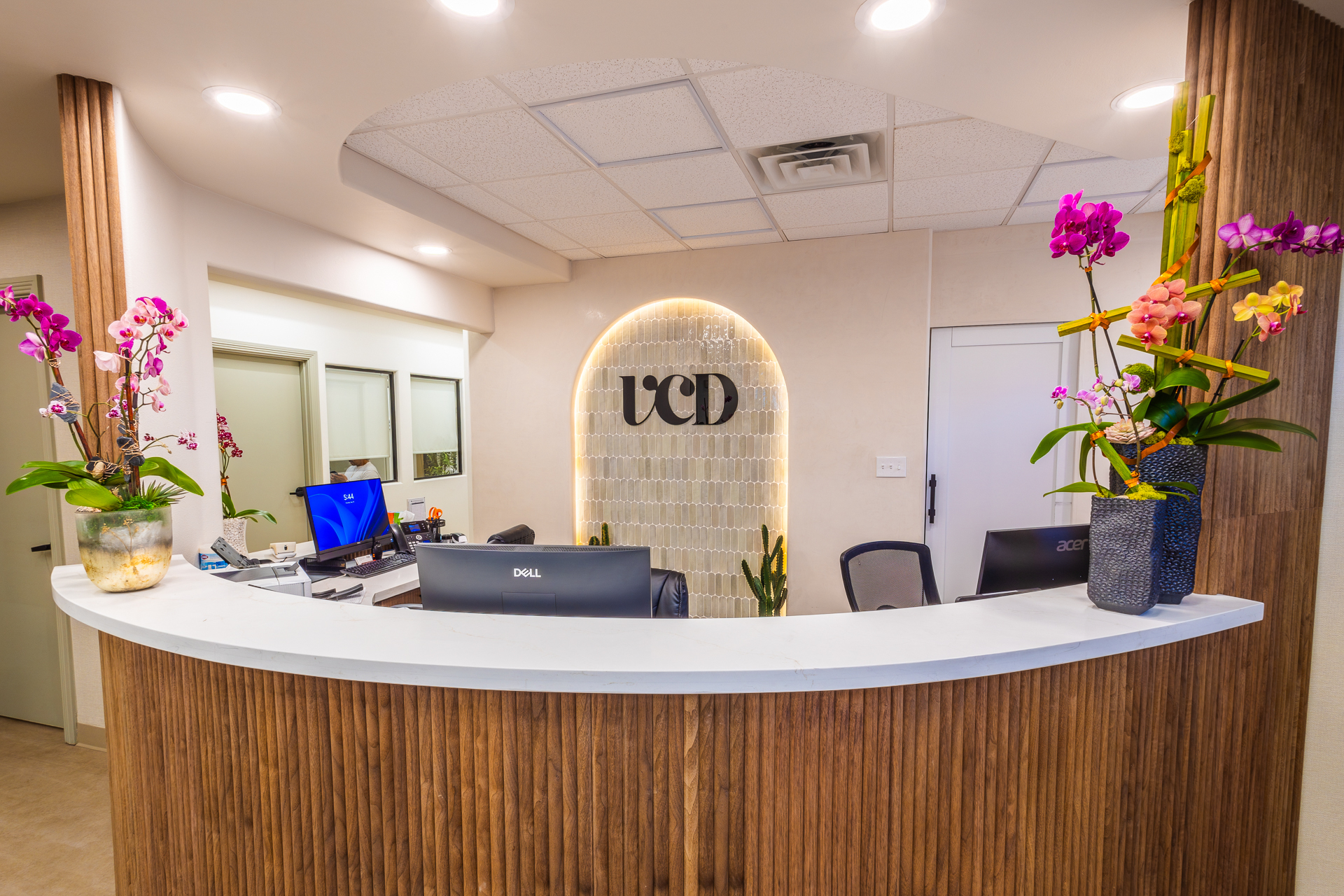 Vegas Choice Dental reception desk with orchids and warm wood accents